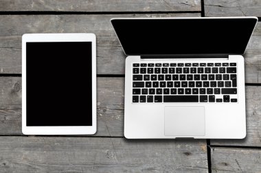 Tablet ve eski ahşap masa üstünde bilgisayar