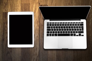 Tablet ve eski ahşap masa üstünde bilgisayar
