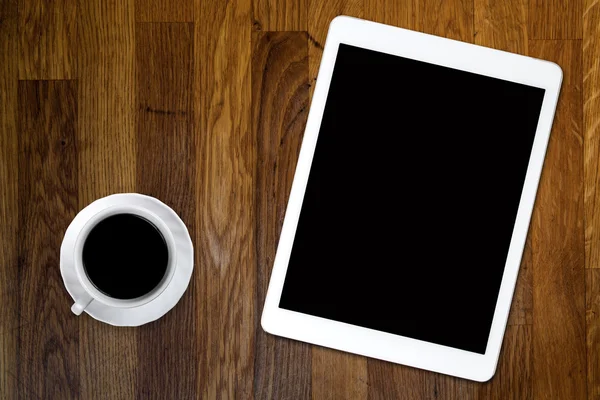 Tablet and coffee on old wooden table — Stock Photo, Image