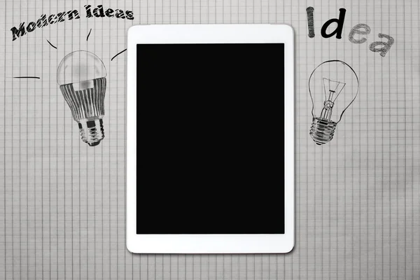 Drawn light bulb on a piece of paper and tablet — Stock Photo, Image