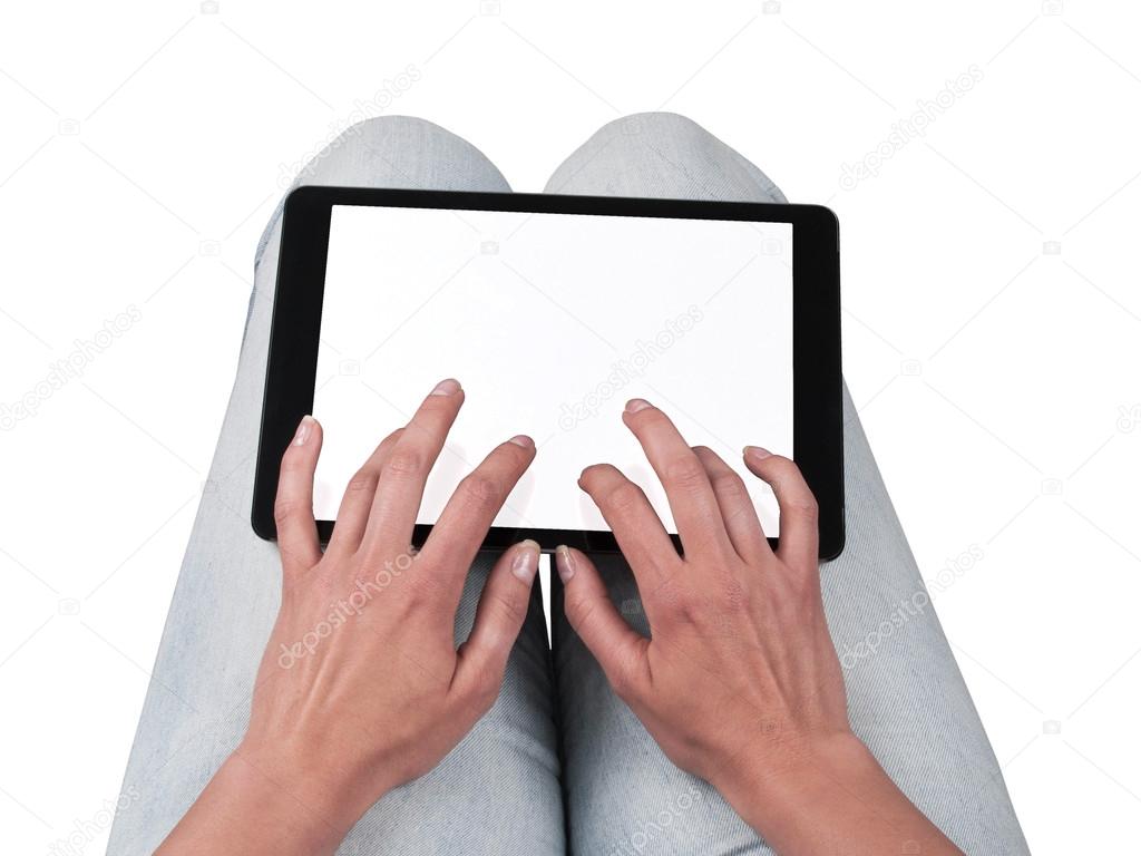 Woman writes on the tablet lying on the thighs
