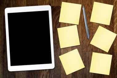 Yapışkan not kağıt ve eski ahşap masa üzerinde kahve fincan ile dijital tablet bilgisayar. Web kullanımı ile basit çalışma alanı veya kahve molası .
