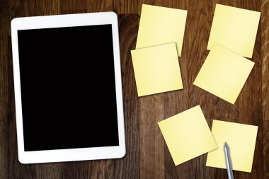 Yapışkan not kağıt ve eski ahşap masa üzerinde kahve fincan ile dijital tablet bilgisayar. Web kullanımı ile basit çalışma alanı veya kahve molası .