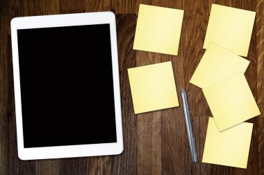 Yapışkan not kağıt ve eski ahşap masa üzerinde kahve fincan ile dijital tablet bilgisayar. Web kullanımı ile basit çalışma alanı veya kahve molası .
