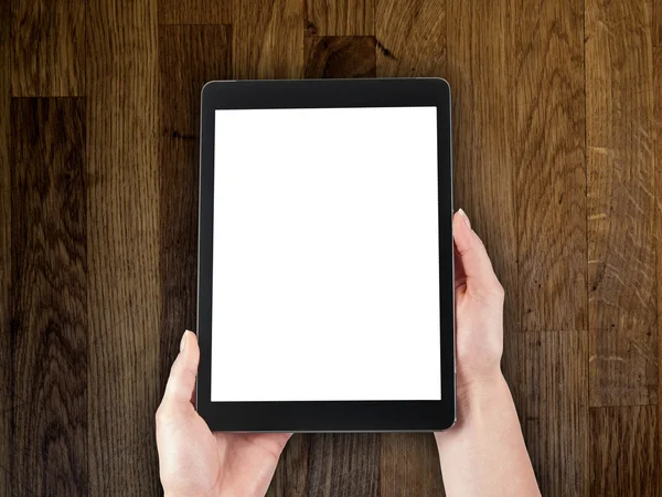 bir tablet ahşap bir masa üstü arka plan üzerinde tutan kadının el