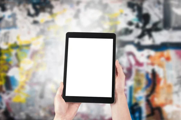 Tablet in the hands of women and graffiti in the background — Stock Photo, Image