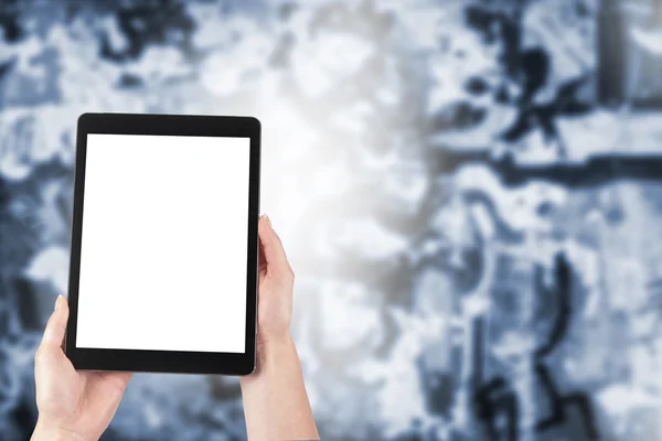 tablet in the hands of women and graffiti in the background