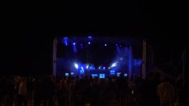 Lion sur Mer, Fransa Ağustos 2021: Açık havada zamansız ücretsiz tekno müzik konseri, renkli şafak dumanı ve lazerler. 4k