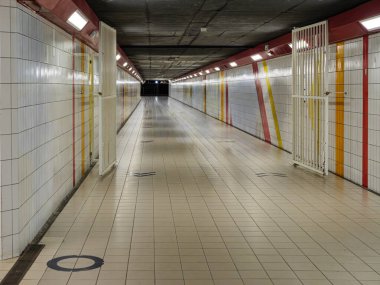 Döşemeli ve duvarlı boş yeraltı yaya tüneli, güçlü doğrusal perspektif ve mükemmel simetri. Kopya alanı ve modern şehir altyapısı olan kentsel mimari arka plan.