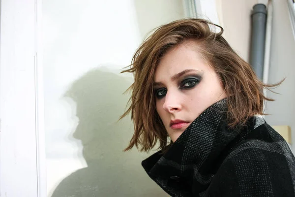 Siyah dumanlı gözlü genç bir kadın. Makyaj malzemesi.