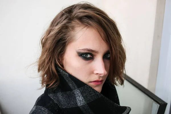 Siyah dumanlı gözlü genç bir kadın. Makyaj malzemesi.