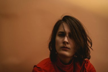 Genç bir kadın kameraya bakıyor.