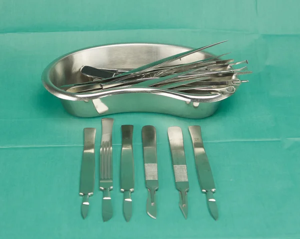 Forceps in kidney shape bowl and scalpel — Stock Photo, Image