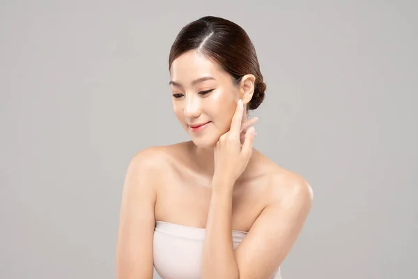 美丽的亚洲女人 用清爽的肌肤触摸着柔软的面颊 快乐而快乐 有着积极的情感 有着白色的背景 美感和美感 — 图库照片