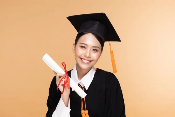 Happy Graduate Asian Woman Cap Gowm Holding Certificated Diploma Beige — Stok Foto