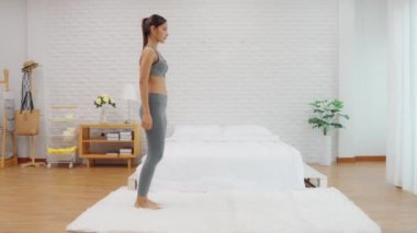 Spor giyinen sağlıklı bir Asyalı kadın yatak odasında spor yapıyor zayıf vücut aerobiği olan genç bir kadın sağlıklı yaşam tarzı kavramı uyguluyor.