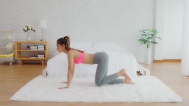Spor giyinen sağlıklı bir Asyalı kadın yatak odasında spor yapıyor zayıf vücut aerobiği olan genç bir kadın sağlıklı yaşam tarzı kavramı uyguluyor.