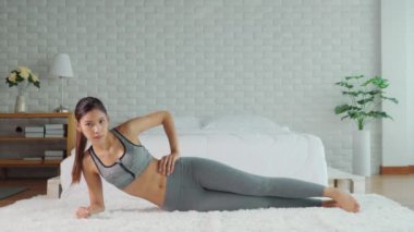 Spor giyinen sağlıklı bir Asyalı kadın yatak odasında spor yapıyor zayıf vücut aerobiği olan genç bir kadın sağlıklı yaşam tarzı kavramı uyguluyor.