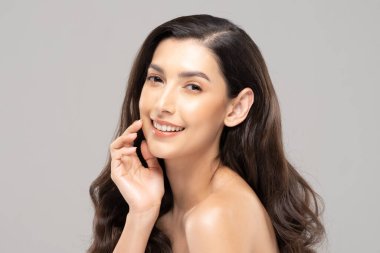 Güzel Cazibeli Hintli kadın temiz ve taze tenli yanak tebessümüne dokunur. Mutluluk ve neşe, olumlu duygusal, gri arka planda soyutlanma, güzellik kozmetiği ve kaplıca tedavisi kavramı.