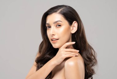 Güzel Cazibeli Hintli kadın çene gülümsemesine temiz ve taze teniyle dokunuyor mutluluk ve neşe olumlu duygusal, gri arka planda soyutlanmış güzellik kozmetiği ve kaplıca tedavisi kavramı