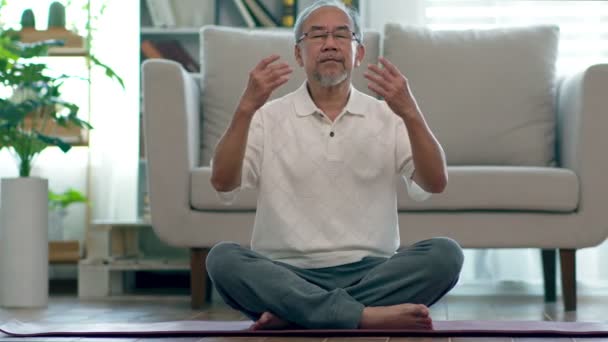 Азиатский Пожилой Мужчина Делает Йогу Медитации Коврик Йоги Гостиной Дому — стоковое видео