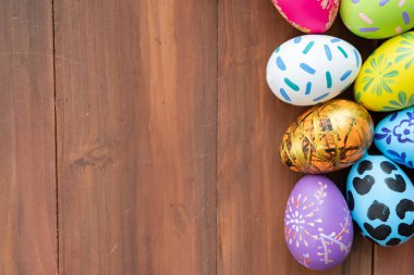Paskalya yumurtaları ahşap zemin üzerinde fotokopi alanı, yumurtaların üzerine renkli ve el yapımı boya Avrupa 'da geleneksel Paskalya Günü için, Paskalya Günü Konsepti