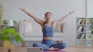 Refah sporcusu Asyalı kadın dizüstü bilgisayarda yoga yapan Hintli kadın evde meditasyon için poz veriyor rahat ve rahat, yoga egzersizi evde konsept, kişisel izolasyon COVID-19 salgını