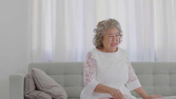 白い髪のアジアの高齢女性の緊急時に自宅でソファの上で胸の痛みや病気を攻撃 高齢者ケアの概念 — ストック動画