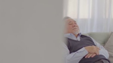 Asyalı kıdemli yakışıklı iş adamının sakinliği. Gözlerini kapat. Evdeki rahat oturma odasında şekerleme yap. 