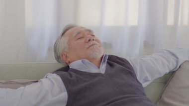 Asyalı kıdemli yakışıklı iş adamının sakinliği. Gözlerini kapat. Evdeki rahat oturma odasında şekerleme yap. 