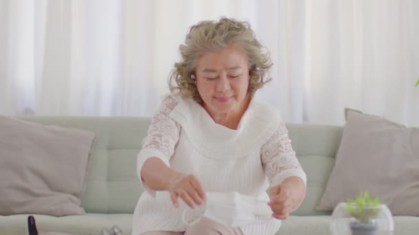 동양인 코로나 바이러스를 예방하기 의료용 마스크를 소파에 거실에 노인들의 새로운 — 비디오