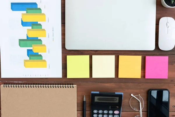 Top view of Business equipment Computer laptop notebook,post it,sale report mouse and coffee on wooden table,Flat lay business concept with copy space