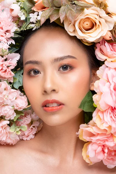 Wellness Beauty Asian Woman looking at camera bouquet of flowers around her face,Pretty young woman with clean and fresh skin shine bright with big beautiful flowers,Beauty Woman with Flowers Concept
