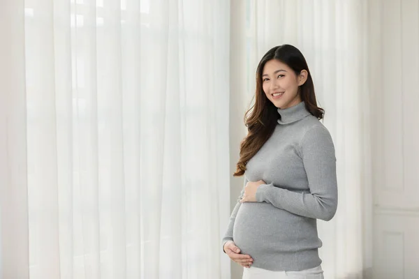 Happy Pregnant Woman Turtleneck Tröja Står Framför Fönster Och Smeker — Stockfoto