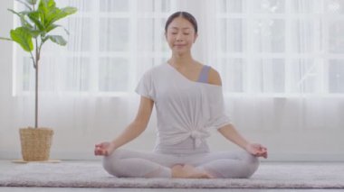 Sağlığın huzuru Asyalı genç kadın halının üzerinde yoga nilüferiyle soluk alıp veriyor, Yoga yapıyor sağlıklı genç bir kadının meditasyonu, beyaz rahat evinde dinleniyor ve rahat, Yoga sağlık egzersizi yapıyor.