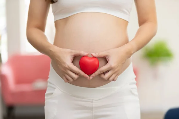 Blisko Palca Kobiety Ciąży Trzyma Brzuchu Kształtowanie Serca Dla Miłości — Zdjęcie stockowe