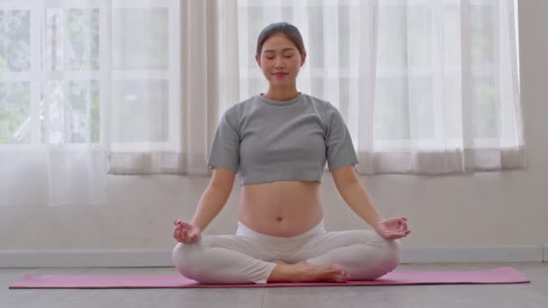 Счастливая Азиатская Беременная Женщина Практикует Йогу Позе Лотоса Большой Грудью — стоковое видео