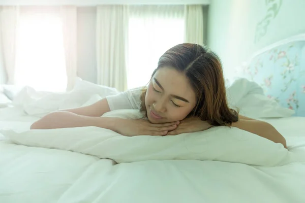 Beautiful Attractive Asian woman wearing Pajamas sleep smile sleep and sweet dream on bed in bedroom in the morning feeling so relax and comfortable,Healthcare and Sleep Concept