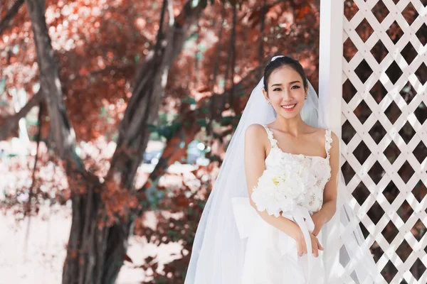 Beautiful Attractive Asian Bride Woman wearing white wedding dress and holding bouquet smile so proud and happiness in wedding day,Bride Concept