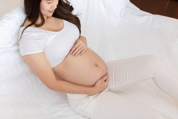Szczęśliwa Kobieta Ciąży Siedzi Łóżku Trzymając Głaskanie Jej Duży Brzuch — Zdjęcie stockowe