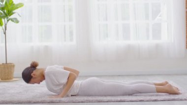 Sağlıklı ve Çekici Asyalı kadın yoga yapıyor. Kobra evde meditasyon yapıyor ve rahatlıyor. Sağlıklı genç kadın derin nefes alıyor ve yoga ile evde meditasyon yapıyor.