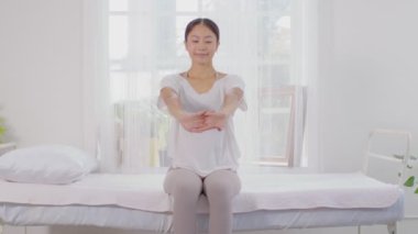Sağlıklı, Asyalı genç bir kadın yatakta soluklanır ve yoga yapmadan önce esner, genç sağlıklı bir kadın beyaz rahat evinde kaslarını ısıtır ve rahatlar, Yoga Sağlık Konsepti