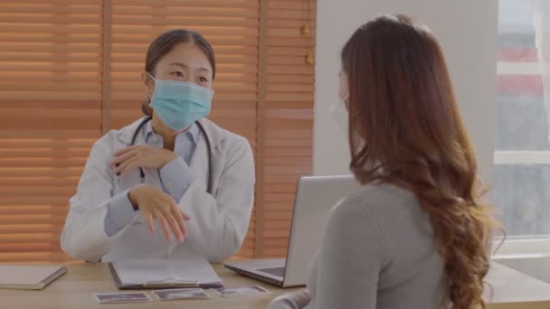 専門的なアジアの医師女性は妊娠中の患者に相談します 病院で患者に話して聴診器で白いコートを着てスマート医師 医師と妊娠中の患者の概念 — ストック動画