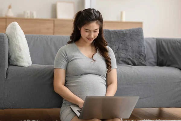 妊娠中のビジネス女性が座って 自宅で販売報告書 タブレット 本や付箋でノートパソコンで作業 ノートパソコンで入力ビジネス女性の妊娠 ビジネスと妊娠の概念 — ストック写真