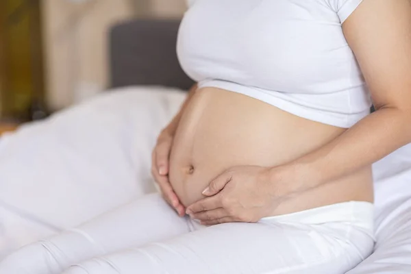 Zamknij Się Happy Trugnant Woman Siedzi Łóżku Gospodarstwa Głaskanie Jej — Zdjęcie stockowe