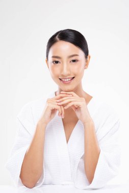 Güzel Asyalı kadın el ele tutuşmuş kameraya bakıyor temiz ve taze bir tenle gülümsüyor mutluluk ve neşeli, olumlu duygusal, beyaz arka planda soyutlanmış, güzellik ve kozmetik kavramı.