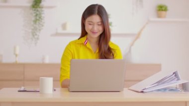 Asyalı iş kadını iş yerindeki bilgisayarını kapat ve kameraya özgüvenli bir şekilde gülümse. Ev işi bittikten sonra Freelancer gülümsemesi ve mutluluğu işaret ediyor.