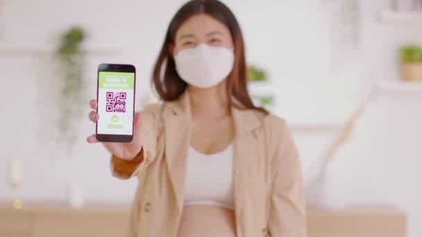 妊娠中の女性は携帯電話でCovid 19予防接種パスポートを保持し 表示します 安全妊娠中のオープンQrコード予防接種パスポート抗ウイルスワクチンを受け取った後 — ストック動画