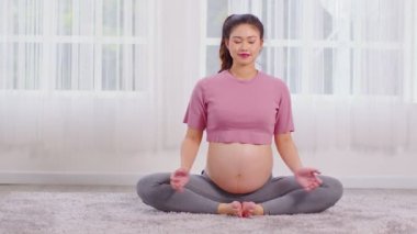 Mutlu Çekici Asyalı Hamile kadın yoga baddha konasana pozunu büyük bir meditasyon gülümsemesiyle uygular. Hamile kadın yoga kelebeğini çok rahat yapar ve rahatlar. Hamilelik konsepti