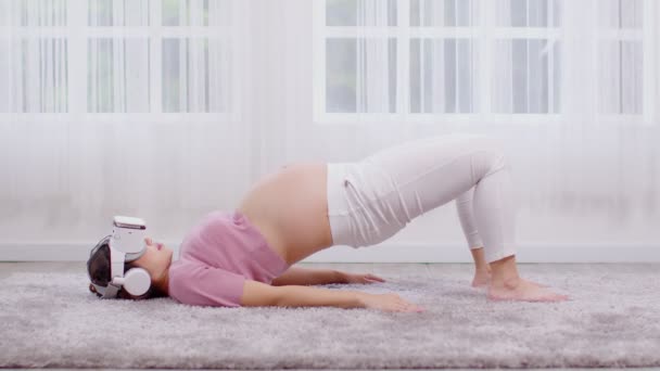 快乐的亚洲孕妇在网上用虚拟现实眼镜练习瑜伽 — 图库视频影像